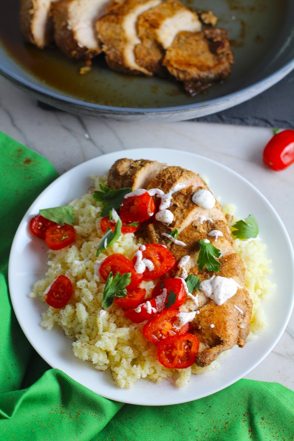 Sliced Mexican Chicken on rice with tomatoes, sour cream, & cilantro. This marinade is an easy, make-ahead, and delicious recipe! The chicken is infused with so much smokey, savory flavors from the fresh garlic, chili powder, and cumin. #marinade #chicken #easydinners