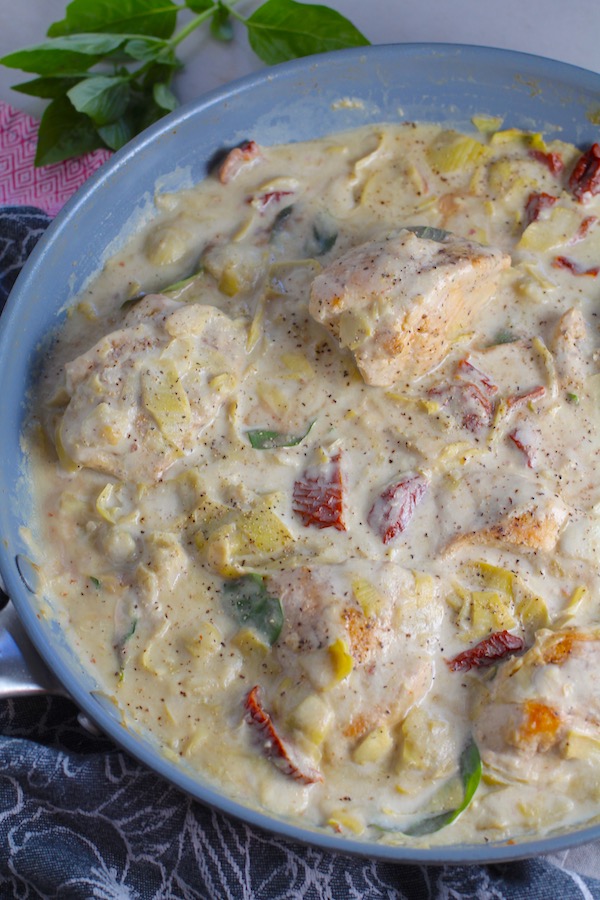 Close up of Skillet Artichoke Chicken with sun dried tomatoes, basil, garlic, in cream sauce.