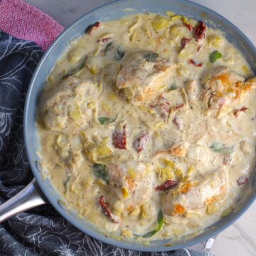 Close up of Skillet Artichoke Chicken with sun dried tomatoes, basil, garlic, in cream sauce. #skilletchicken #skilletdinner #chicken #easydinner #familydinner #italian #tuscanchicken