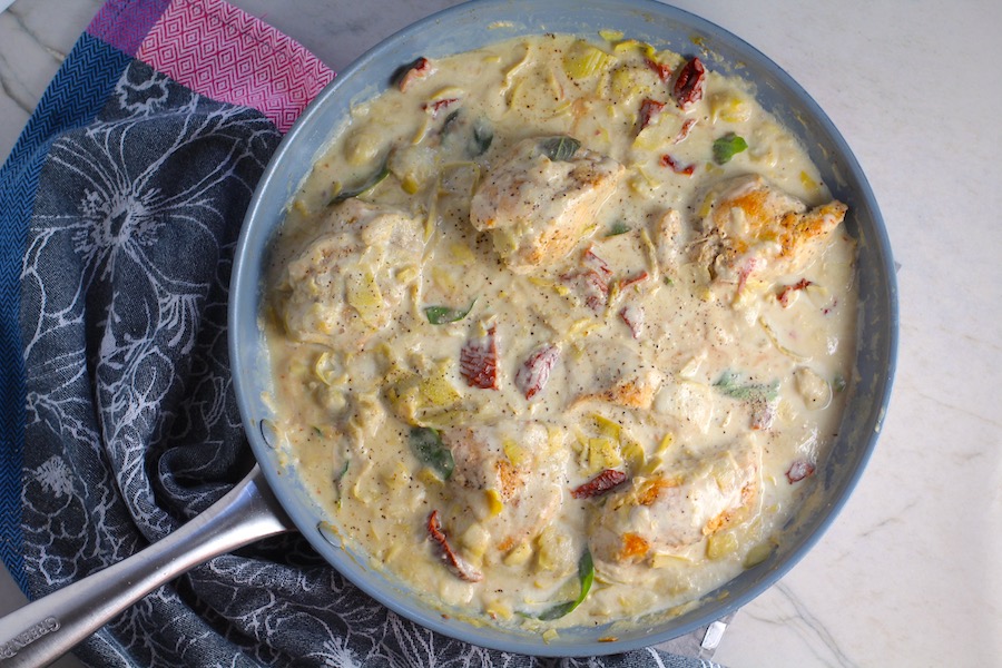 Close up of Skillet Artichoke Chicken with sun dried tomatoes, basil, garlic, in cream sauce. #skilletchicken #skilletdinner #chicken #easydinner #familydinner #italian #tuscanchicken