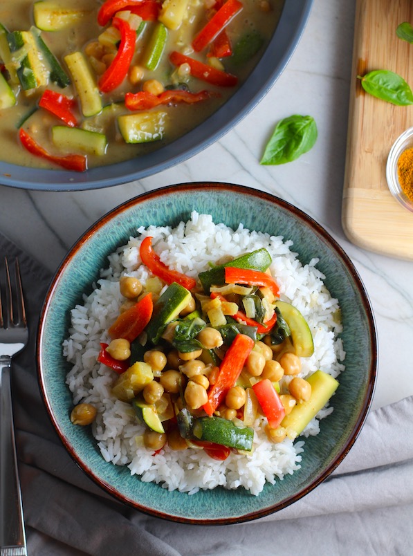 Family Zucchini Chickpea Curryover rice in a bowl with red bell pepper, zucchini, onion, coconut milk, and warm Indian Curry spices.