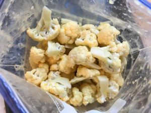Cauliflower florets mixed with beaten eggs for Baked Coconut Cauliflower Bites. They have a slightly sweet and salty crunch outside from the shredded coconut and panko mixture. The inside is soft and creamy. Dip in the Sriracha Mayo. Baked, not fried, so healthy! Easy to make, easy to eat! #cauliflowerrecipes #healthyrecipes #sidedishes #appetizers #healthysnacks
