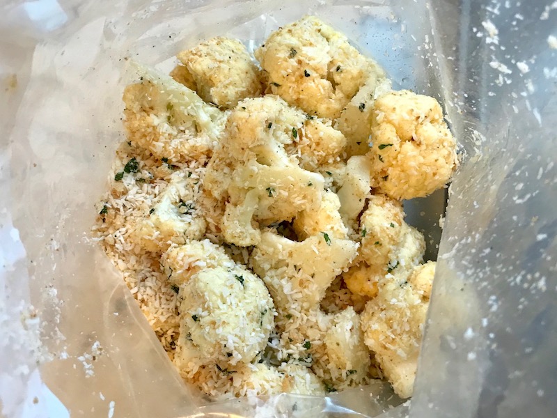 Cauliflower florets mixed with coconut breadcrumbs for Baked Coconut Cauliflower Bites. They have a slightly sweet and salty crunch outside from the shredded coconut and panko mixture. The inside is soft and creamy. Dip in the Sriracha Mayo. Baked, not fried, so healthy! Easy to make, easy to eat! #cauliflowerrecipes #healthyrecipes #sidedishes #appetizers #healthysnacks