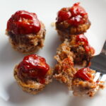 Mini Meatloaf Muffins on a plate. They have only 5 simple ingredients, cook in 30 minutes, and are gluten free. Parmesan gives salty and nutty flavor.  Ketchup on top cooks down into a thick, deep-flavored tangy, salty, and sweet glaze.