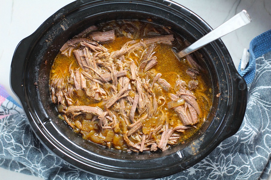 Smoky Pulled Beef Brisket in the Slow Cooker is smokey, savory, tender, moist, and full of flavor. In a delicious sauce, it goes great on a sandwich, over polenta, on rice, or potatoes. #slowcooker #crockpot #brisket #beefbrisket #pulledbeef #pulledpork