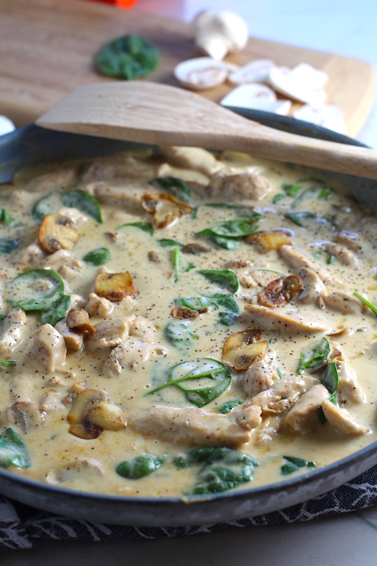 Chicken Mushroom Stroganoff in a skillet with mushrooms and spinach. It has a thick, creamy, savory mushroom sauce with a touch of tangy sour cream.