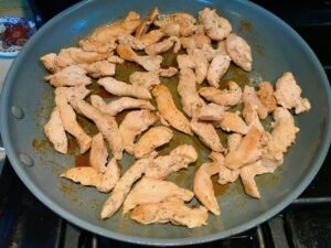 Cooked chicken strips in pan for Chicken Stroganoff with mushrooms, and spinach. It has a thick, creamy, savory mushroom sauce with a touch of tangy sour cream. #chickendinners #chickenrecipes #familydinners #dinnerideas