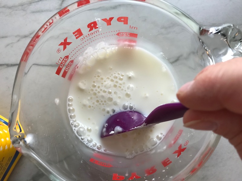 Cornstarch being added to milk for Chicken Stroganoff with mushrooms, and spinach. It has a thick, creamy, savory mushroom sauce with a touch of tangy sour cream. #chickendinners #chickenrecipes #familydinners #dinnerideas