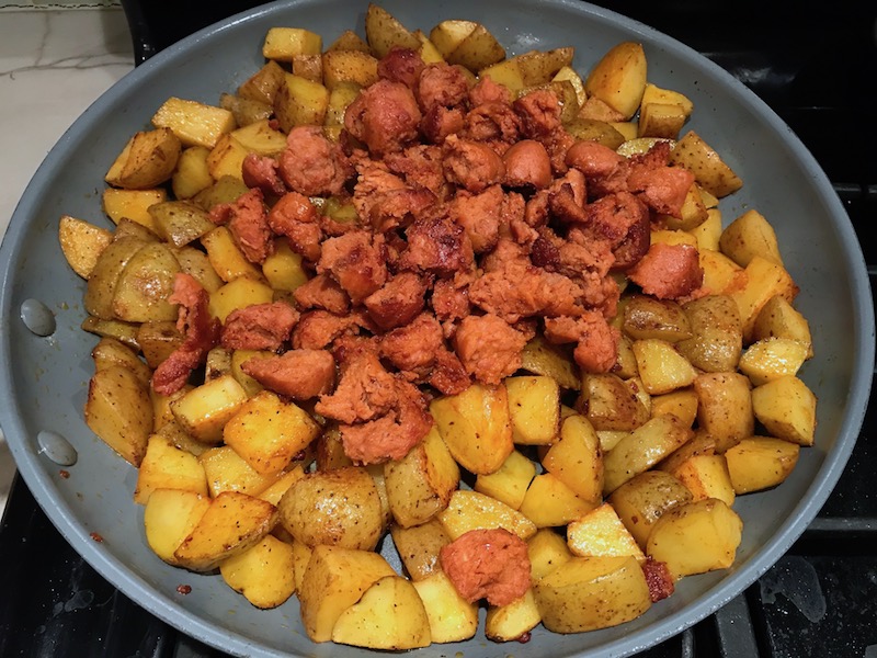 Chorizo and potatoes in skillet for Patatas Bravas with chorizo and creamy Paprika aioli. This Patatas Bravas Recipe, or Spicy Potatoes, is easy, indulgent, and utterly delicious! #potatorecipes #potatoes #potatosidedishes #patatasbravas #skilletpotatoes #sidedishes #chorizo