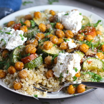 Mediterranean SHEET PAN DINNER on a plate with chicken sausage, parmesan zucchini. and crispy chickpeas over quinoa with dollops of seasoned Ricotta. #sheetpandinner #chickpeas