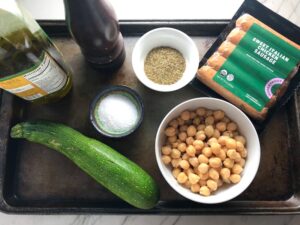 Ingredients for Mediterranean SHEET PAN DINNER with chicken sausage, parmesan zucchini. and crispy chickpeas. Serve over quinoa with dollops of seasoned Ricotta. #sheetpandinner #chickpeas