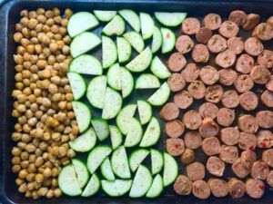 Mediterranean SHEET PAN DINNER with chicken sausage, parmesan zucchini. and crispy chickpeas. Serve over quinoa with dollops of seasoned Ricotta. #sheetpandinner #chickpeas