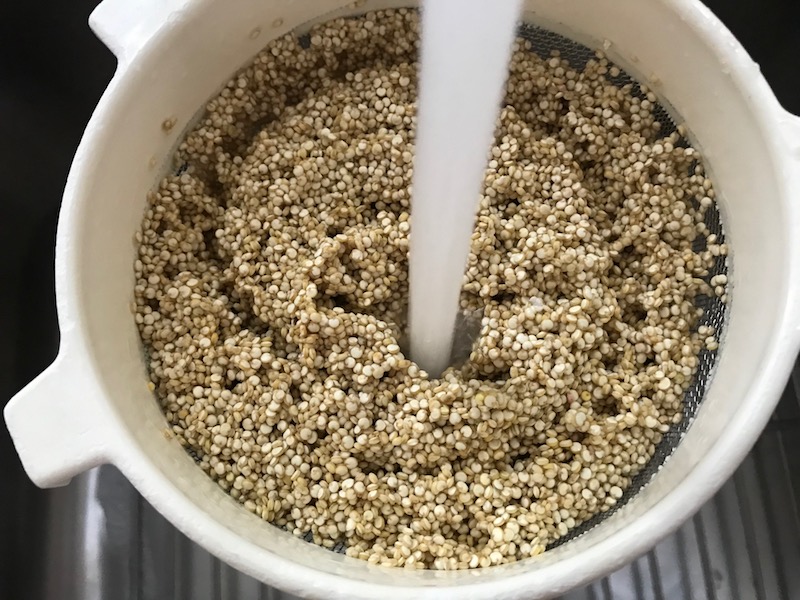 Rinsing quinoa in strainer for Mediterranean SHEET PAN DINNER with chicken sausage, parmesan zucchini. and crispy chickpeas. Serve over quinoa with dollops of seasoned Ricotta. #sheetpandinner #chickpeas