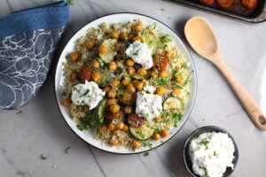 Mediterranean SHEET PAN DINNER on a plate with chicken sausage, parmesan zucchini. and crispy chickpeas over quinoa with dollops of seasoned Ricotta. #sheetpandinner #chickpeas