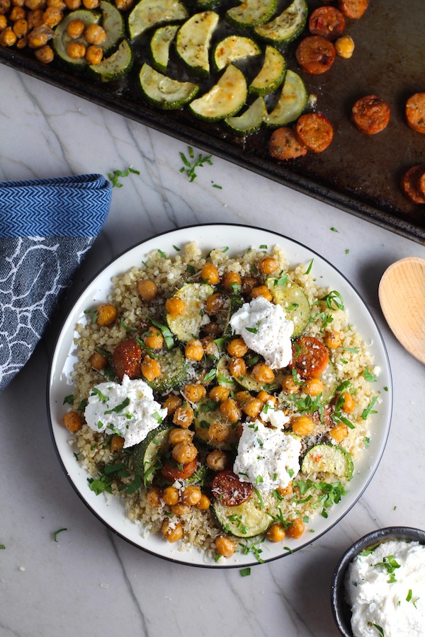 Mediterranean SHEET PAN DINNER on a plate with chicken sausage, parmesan zucchini. and crispy chickpeas over quinoa with dollops of seasoned Ricotta. #sheetpandinner #chickpeas