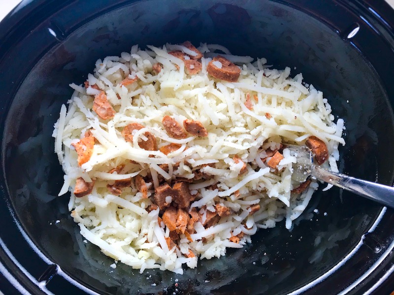 Raw hash browns and chorizo in Slow Cooker for Egg Casserole with Chorizo, Potatoes and both cheddar and manchego cheeses. IT COOKS WHILE YOU SLEEP! #eggs #eggcasseroles #eggrecipes #breakfastideas #holidayrecipe