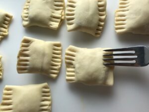 Fork sealing uncooked Mini Beef Wellington Bites. They are flaky and buttery Puff Pastry is filled with a creamy mushroom and parmesan filling and tender beef filet. #appetizers #partyfood