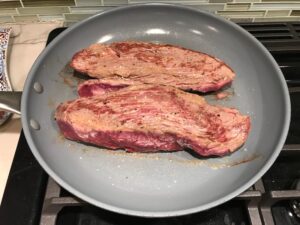 Seared raw Beef Filet in pan for Mini Beef Wellington Bites. They are flaky and buttery Puff Pastry is filled with a creamy mushroom and parmesan filling and tender beef filet. #appetizers #partyfood