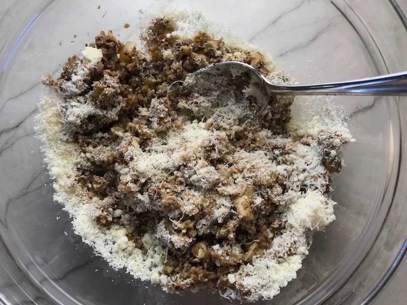 Mixing mushrooms and parmesan in bowl for Mini Beef Wellington Bites. They are flaky and buttery Puff Pastry is filled with a creamy mushroom and parmesan filling and tender beef filet. #appetizers #partyfood