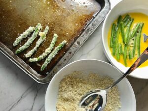 Making Parmesan Green Bean Fries and putting on sheet pan. Such a great way to transform beans and add a new vegetable into dinner rotation. #vegetablerecipes