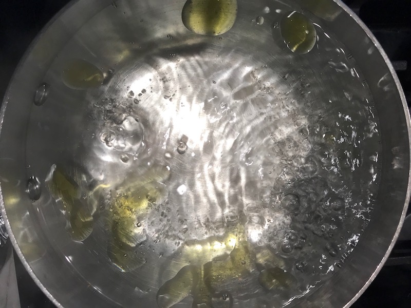 Boiling water with oil in pot for the Orange Brown Butter Shrimp Pasta Recipe. It has a silky sauce that's buttery, nutty, and slightly sweet! #shrimprecipes #shrimppasta #easydinners #dinnerideas
