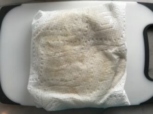 Corn tortilla wrapped in papertowel for Chicken Taquitos. Corn tortillas are filled with smoky taco seasoned shredded chicken, and creamy cheddar cheese. #dinnerideas #familydinner #chickenrecipes #chickendinner #tacos #taquitos