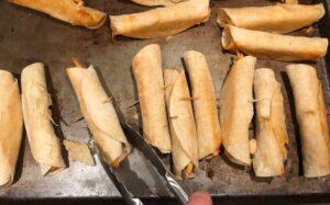 Baked Chicken Taquitos on pan. Corn tortillas are filled with smoky taco seasoned shredded chicken, and creamy cheddar cheese. #dinnerideas #familydinner #chickenrecipes #chickendinner #tacos #taquitos