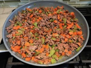 Beef filling in pan for Cottage Pie recipe. It has Spanish Chorizo and ground beef cooked in a rich and savory gravy with veggies and herbs. Creamy mashed potatoes sit on top with manchego, parmesan, and garlic. #dinnerideas #cottagepie #shepherdspie