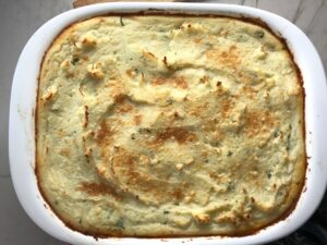 Cooked Cottage Pie recipe. It has Spanish Chorizo and ground beef cooked in a rich and savory gravy with veggies and herbs. Creamy mashed potatoes sit on top with manchego, parmesan, and garlic. #dinnerideas #cottagepie #shepherdspie