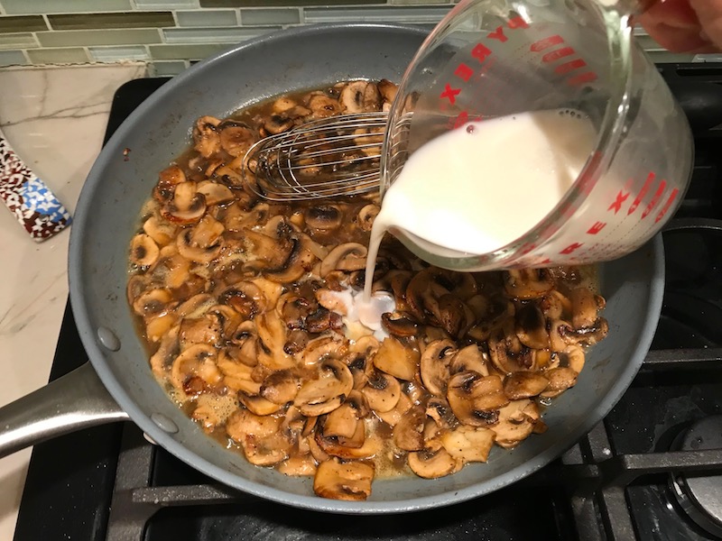 Adding slurry to cooked sliced Mushrooms in skillet for this Heavenly Mushroom Sauce Recipe. #vegetarian #healthydinner #dinnerideas #mushrooms