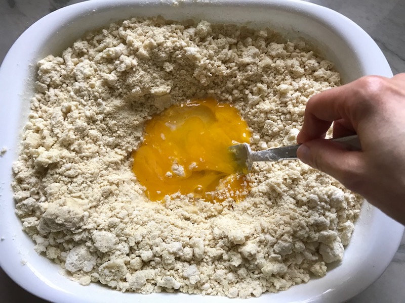 Mixing egg in center of cauliflower gnocchi dough in dish for Cauliflower Gnocchi, which are soft, silky, buttery, and melt-in-your-mouth! Made with cauliflower, they're a healthier version to traditional gnocchi! Add my simple Garlic Butter Sauce or Tomato Sauce and they are heaven. #dinnerideas #gnocchi #cauliflower