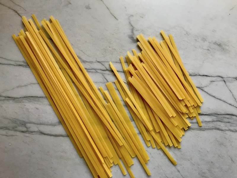 Fettuccine pasta broken in half for Bacon Mac and Cheese. It has a creamy and cheesy sauce with a touch of smokiness from the bacon, coats each piece of pasta. On top, crispy crunchy, indulgent bacon fat cracker crumbs!