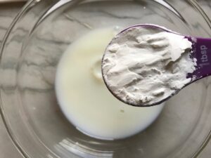 Adding cornstarch to milk for Bacon Mac and Cheese. It has a creamy and cheesy sauce with a touch of smokiness from the bacon, coats each piece of pasta. On top, crispy crunchy, indulgent bacon fat cracker crumbs!