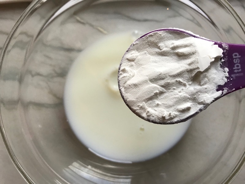 Adding cornstarch to milk for Bacon Mac and Cheese. It has a creamy and cheesy sauce with a touch of smokiness from the bacon, coats each piece of pasta. On top, crispy crunchy, indulgent bacon fat cracker crumbs!