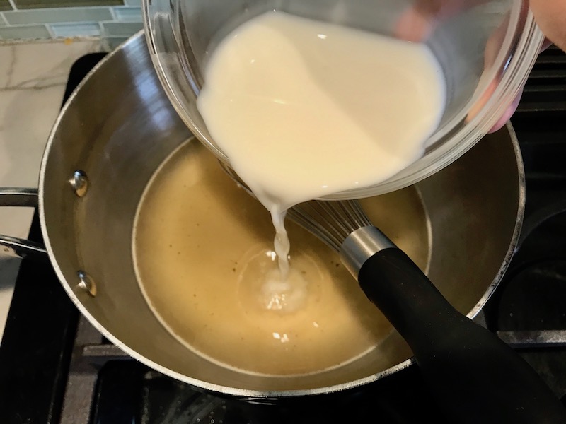 Adding cornstarch slurry to broth for Bacon Mac and Cheese. It has a creamy and cheesy sauce with a touch of smokiness from the bacon, coats each piece of pasta. On top, crispy crunchy, indulgent bacon fat cracker crumbs!