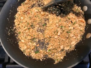 Cracker crumbs and parsley in pan for Bacon Mac and Cheese. It has a creamy and cheesy sauce with a touch of smokiness from the bacon, coats each piece of pasta. On top, crispy crunchy, indulgent bacon fat cracker crumbs!