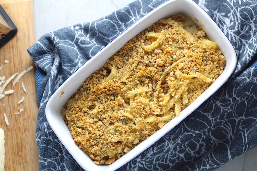 Bacon Mac and Cheese in baking dish. It has a creamy and cheesy sauce with a touch of smokiness from the bacon, coats each piece of pasta. On top, crispy crunchy, indulgent bacon fat cracker crumbs!