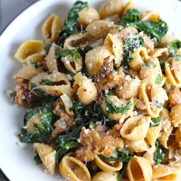 Italian Chicken Sausage Pasta with Kale on a plate. It's loaded with a salty homemade Chicken Italian Sausage flavored with garlic and fennel in a parmesan, garlic and kale sauce.