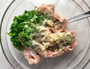 Italian Sausage ingredients in bowl for Shell Pasta with Italian Sausage and Kale. It's loaded with a salty homemade Chicken Italian Sausage flavored with garlic and fennel in a parmesan, garlic and kale sauce.