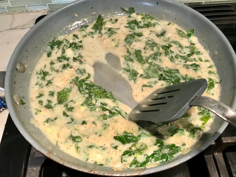 Thickened Kale sauce in pan for Shell Pasta with Italian Sausage and Kale. It's loaded with a salty homemade Chicken Italian Sausage flavored with garlic and fennel in a parmesan, garlic and kale sauce.