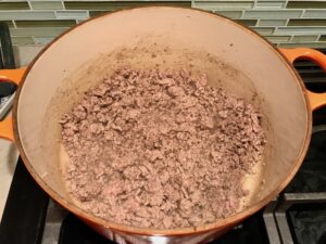 Beef cooking in pot for Chili Mac and Cheese. This Recipe has creamy and cheesy pasta topped with smokey, tangy, savory beef chili! #macandcheese #chilirecipes