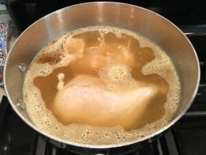 Chicken boiling for Creamy Chicken Green Enchilada Soup. It's creamy, hearty, slightly spicy with green chiles and smokey seasonings that bring so much depth. Corn tortilla strips act like the noodles in this soup!