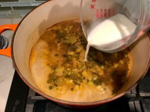 Adding slurry to soup for Creamy Chicken Green Enchilada Soup. It's creamy, hearty, slightly spicy with green chiles and smokey seasonings that bring so much depth. Corn tortilla strips act like the noodles in this soup!