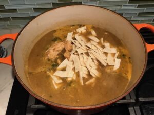 Chicken and tortillas added to soup for Creamy Chicken Green Enchilada Soup. It's creamy, hearty, slightly spicy with green chiles and smokey seasonings that bring so much depth. Corn tortilla strips act like the noodles in this soup!