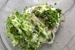 Ingredients in a bowl for Tzatziki sauce to go with Chicken Greek Meatballs. These meatballs have garlic, feta, parsley, and oregano.