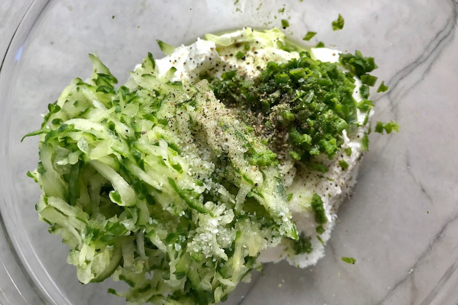Ingredients in a bowl for Tzatziki sauce to go with Chicken Greek Meatballs. These meatballs have garlic, feta, parsley, and oregano.