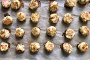 Baked Ground Chicken Greek Meatballs on a pan. These meatballs have garlic, feta, parsley, and oregano
