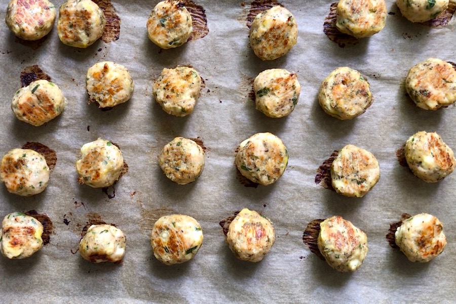 Baked Ground Chicken Greek Meatballs on a pan. These meatballs have garlic, feta, parsley, and oregano