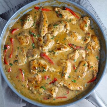 Tarragon Mustard Sauce for Chicken Without Cream with red peppers in a pan on towel on counter. It gets so much flavor from dijon mustard, tarragon, garlic, and onion. It's an easy-to-whip-up any night dinner!
