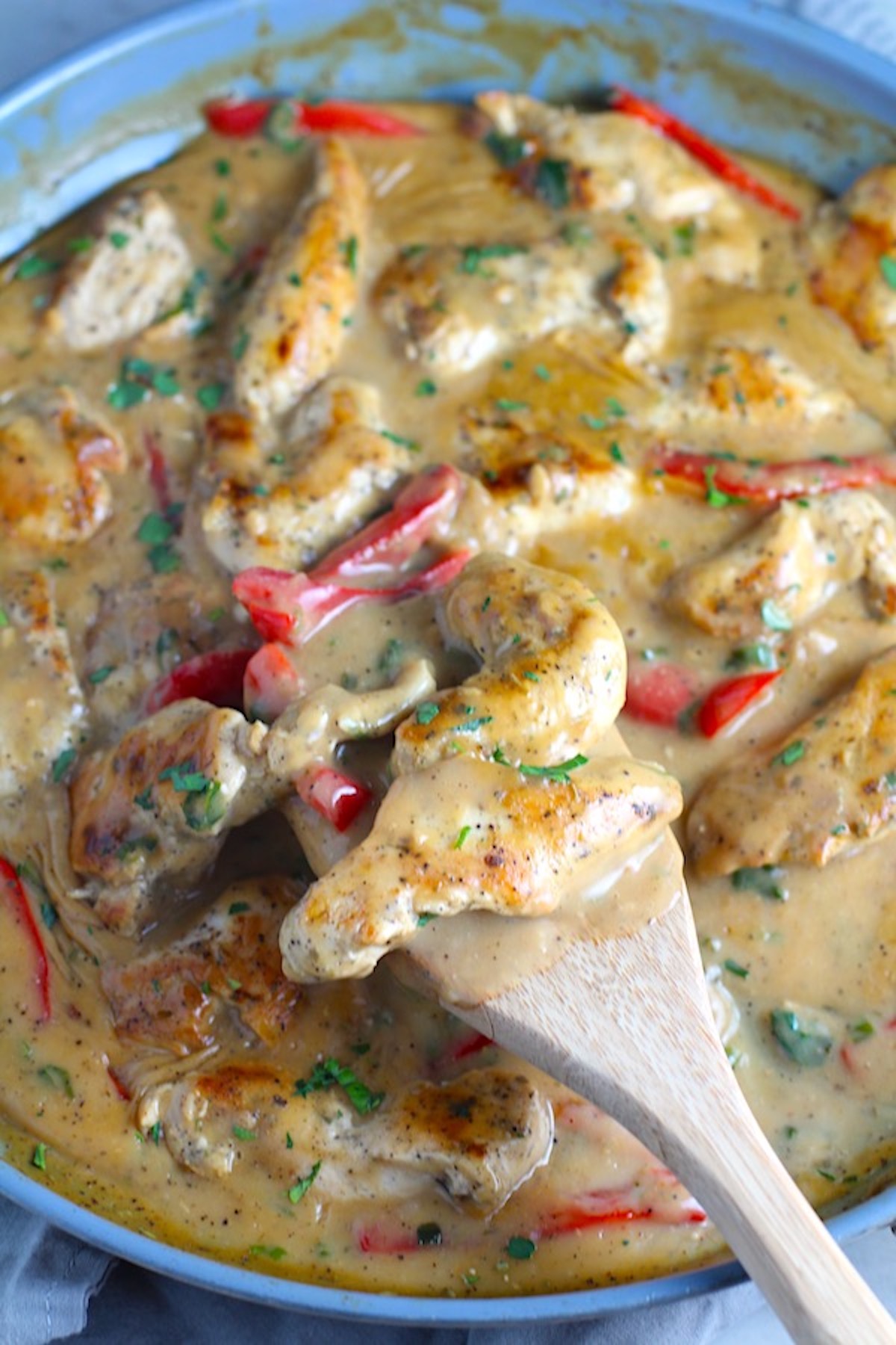 Tarragon Mustard Sauce for Chicken Without Cream with red peppers being scooped up from a pan with wood spatula. It gets so much flavor from dijon mustard, tarragon, garlic, and onion. It's an easy-to-whip-up any night dinner!